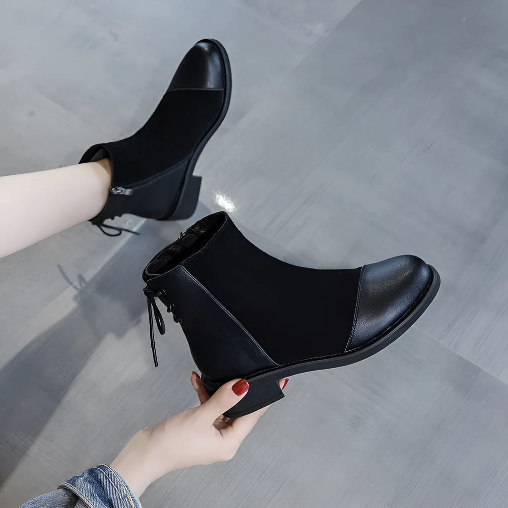 Black women's knee-high Martin boots with side zip, bow detail, and a round toe on a non-slip rubber sole.