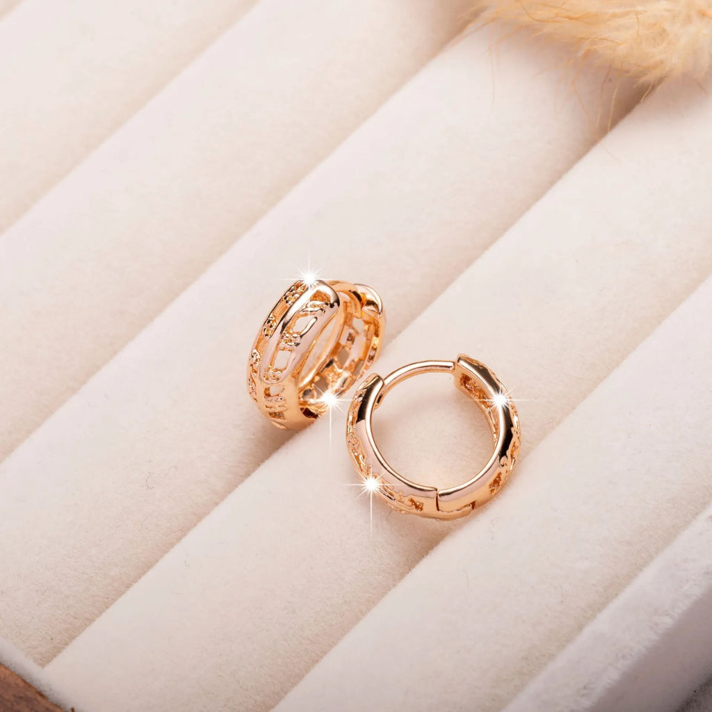 Rose gold plated copper earrings with hollowed-out leaf and heart shapes creating intricate cut-out patterns