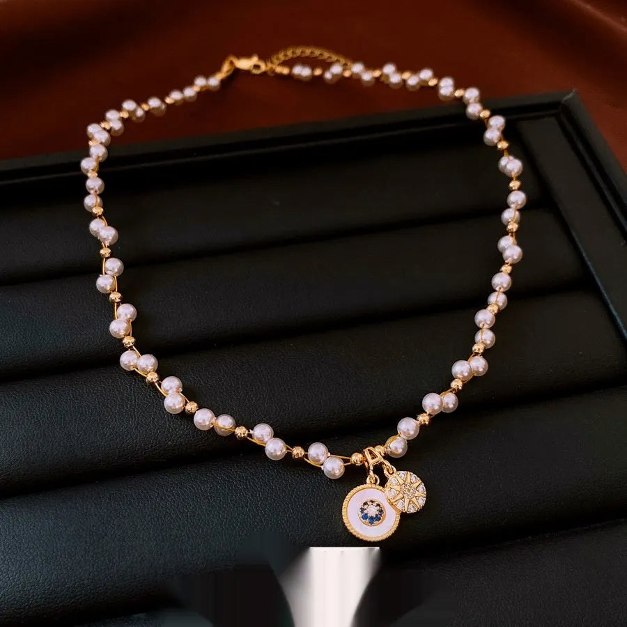 Gold electroplated necklace with round imitation pearl pendant and zircon accents on clavicle-length chain