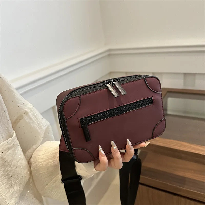 Women's small square PU crossbody bag in black with sewing line detail, single shoulder strap, and external pocket