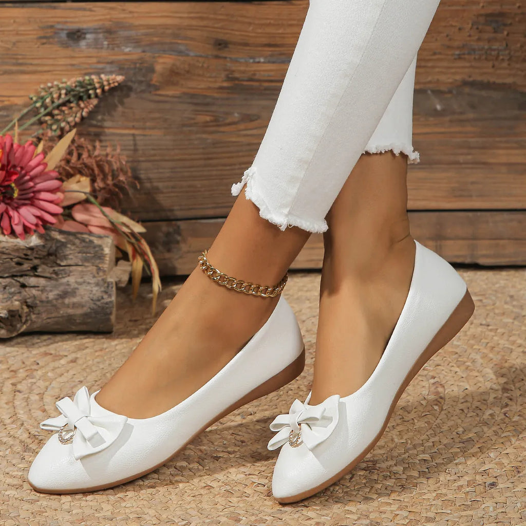 Women's beige casual flat loafers with a bowknot on the front, showing the shallow mouth and rubber sole.