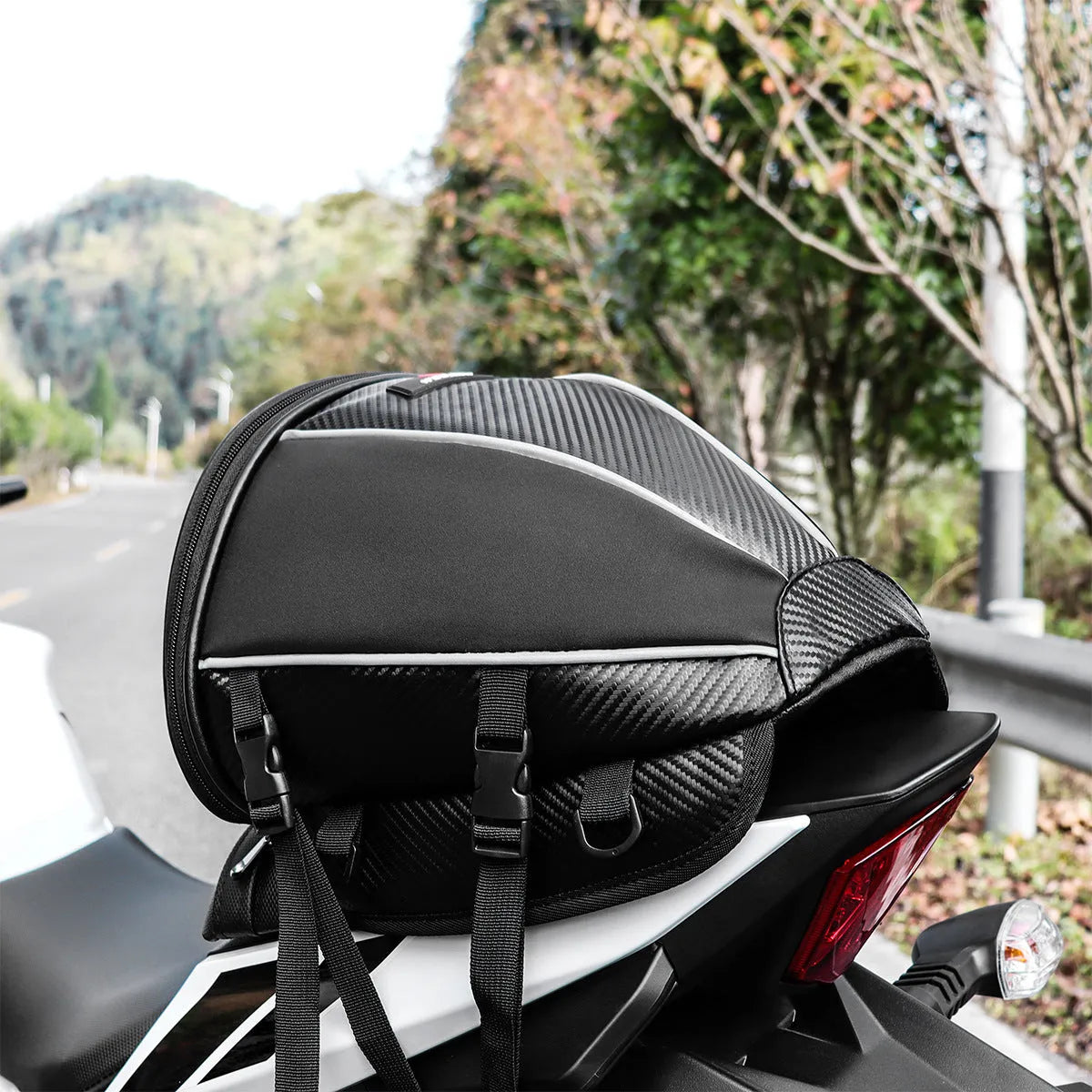Black motorcycle fuel tank bag with reflective stripe, 15-litre capacity, mounted on a motorcycle seat