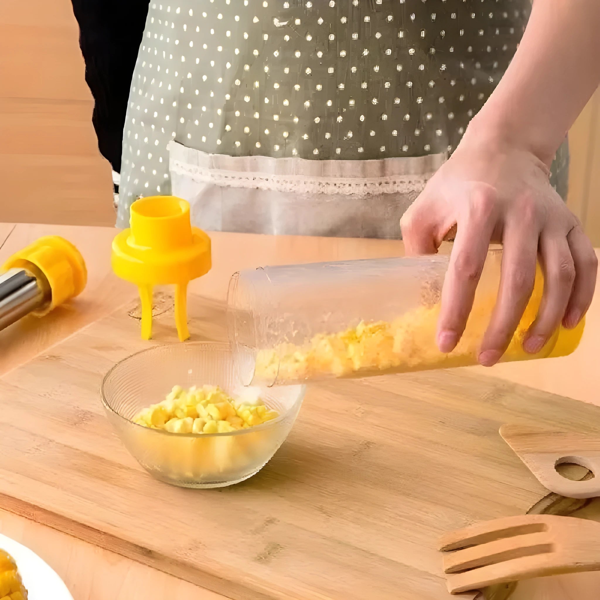 Yellow manual corn stripper with cylindrical ABS plastic body and stainless steel cutting surface on white background