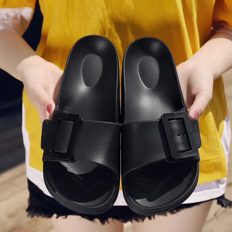 Women's grey blue buckle strap slippers with a soft EVA sole on a light background.