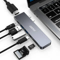Compact silver USB-C multi-port adapter with SD card slot, HDMI, USB ports, and Thunderbolt 3 connector