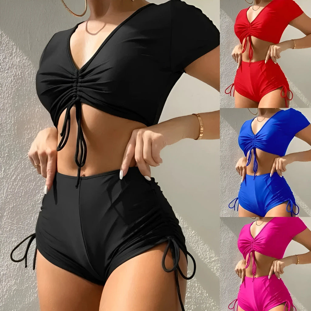 Women's dark green lace-up bow swimsuit top with matching shorts laid flat.
