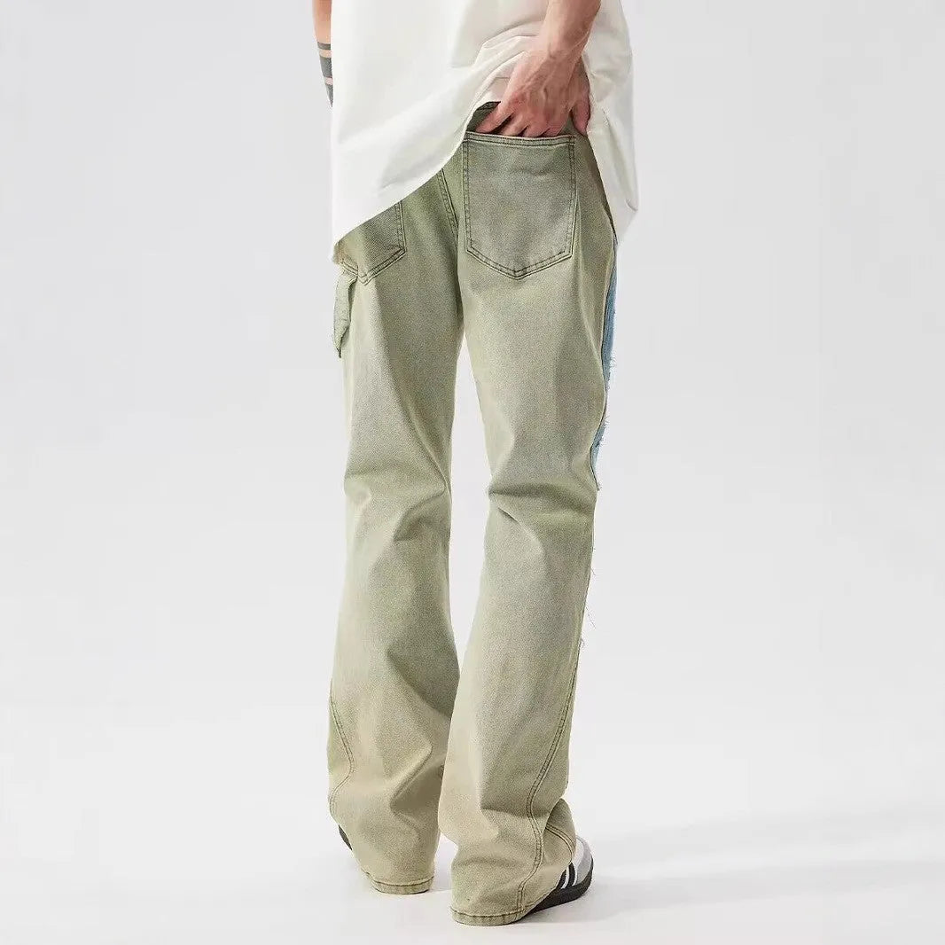 Yellow and blue retro patchwork jeans with a splash-ink damaged design, shown on a mannequin.