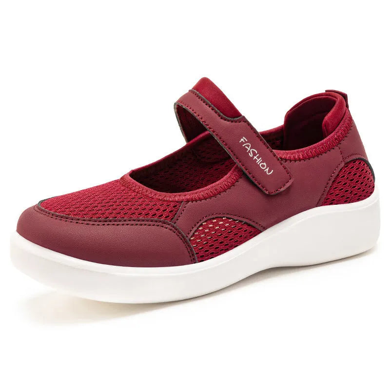 Women's grey low-top cloth shoes with mesh upper and Velcro strap on a flat sole.