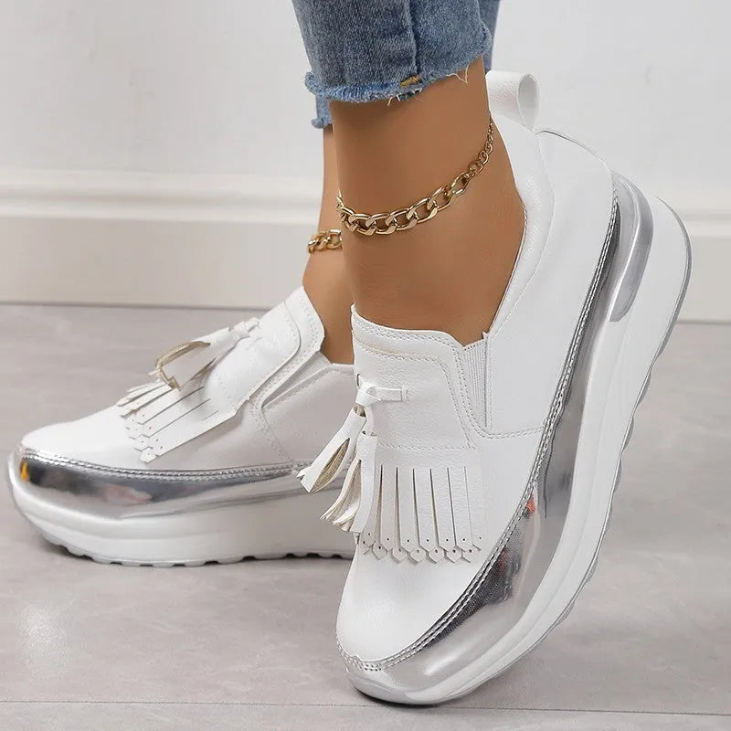 Women's black tassel platform casual shoe with wedge heel, low top, and round toe on a white background