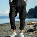 Men's ankle-tied loose fit linen casual trousers in army green, showing multiple pockets and drawstring waist.