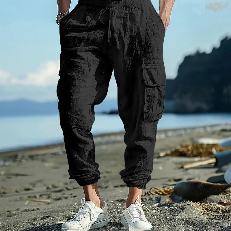 Men's ankle-tied loose fit linen casual trousers in army green, showing multiple pockets and drawstring waist.