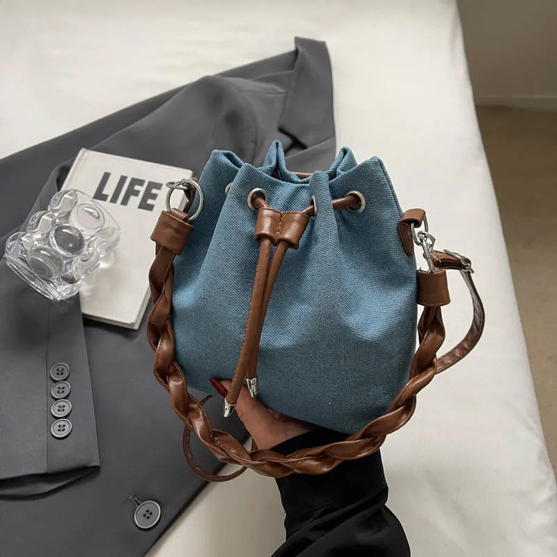 Blue synthetic leather cross body bucket bag with one-shoulder strap and outer pocket