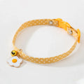 Green adjustable cat collar with a metal bell and red bow tie on a white background.