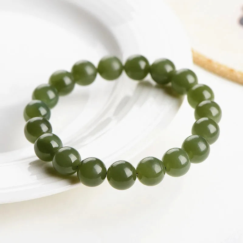 Polished Hetian jade ball bracelet in ice-like clear water colour on a wrist, showing bead detail.