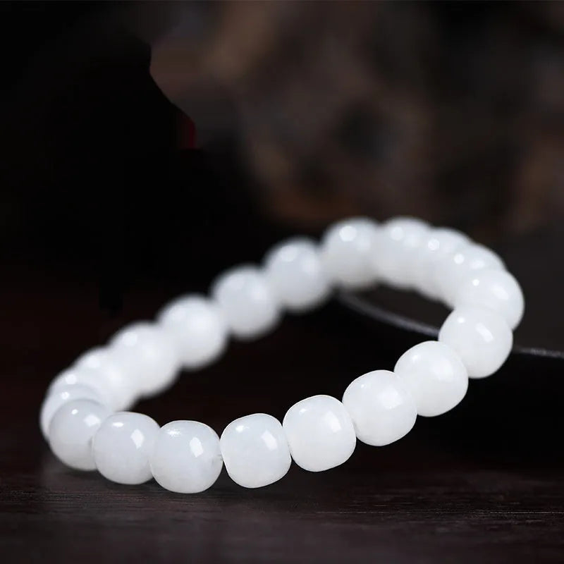 White Hetian jade barrel bead bracelet on a wrist, showing the unisex casual design.