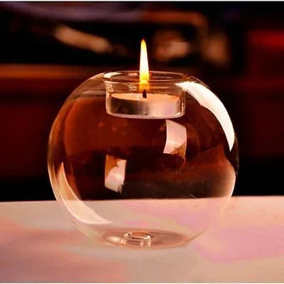 Handblown round hollow glass candle holder on a table, shown in frosted and clear finishes.