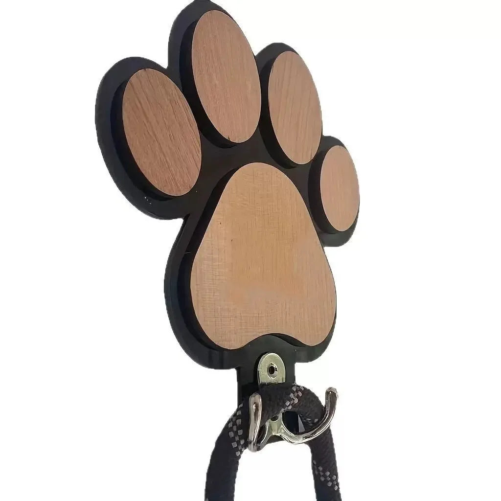 Wooden foot paw print hook in black colour on a white wall for household organisation