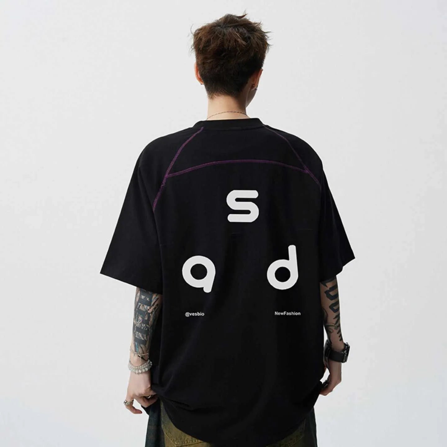 Man wearing a black loose-fit cotton short-sleeve T-shirt with a round neck collar.