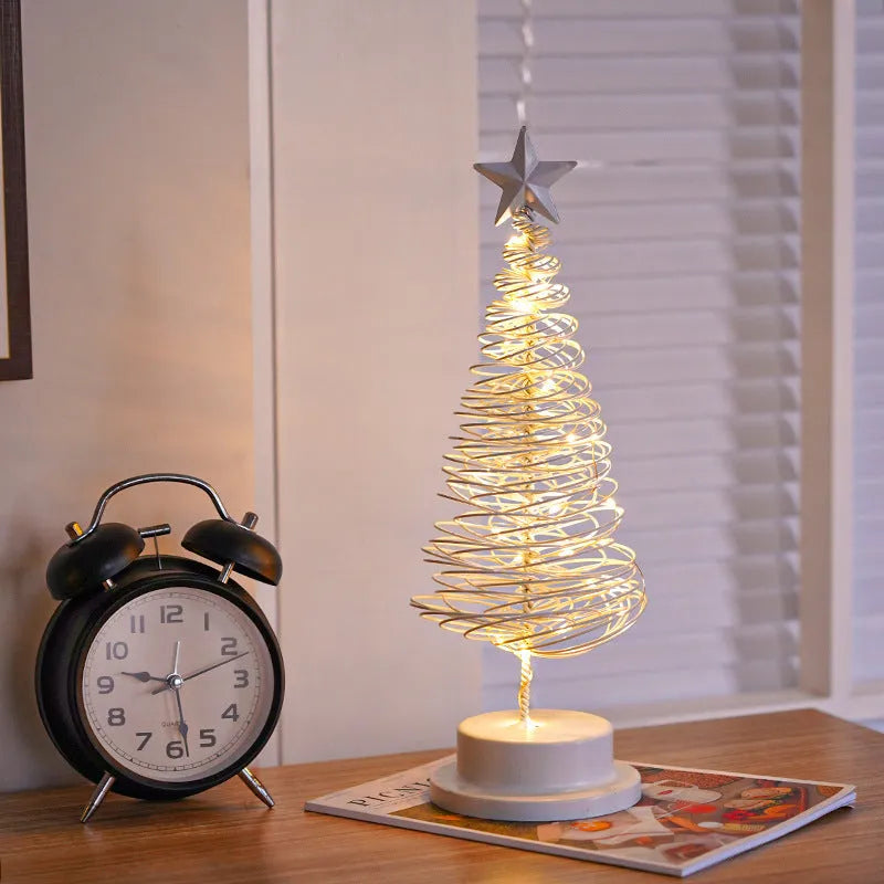 LED Christmas tree spiral light ornament with warm white glow on a table, gold finish