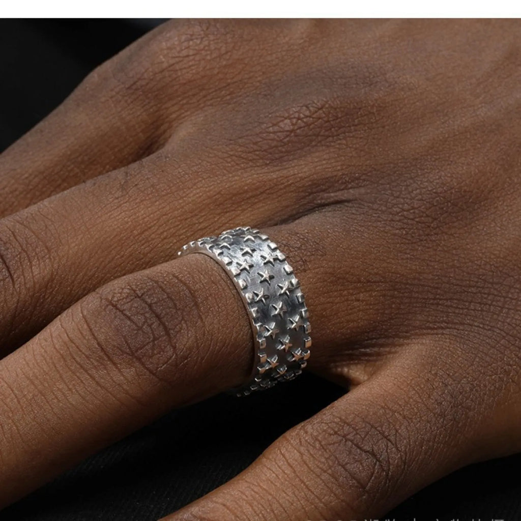 Adjustable open-band sterling silver ring with a raised five-pointed star geometric design.