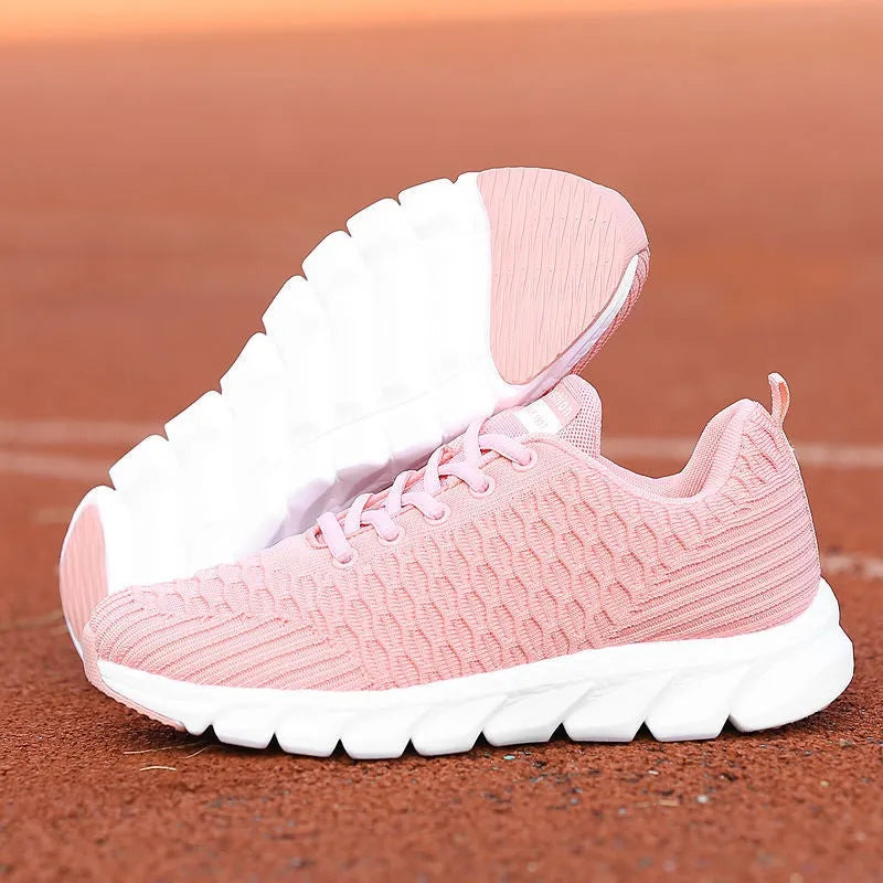 Women's running shoes in black, pink, or white with a fly weave upper and durable sole.