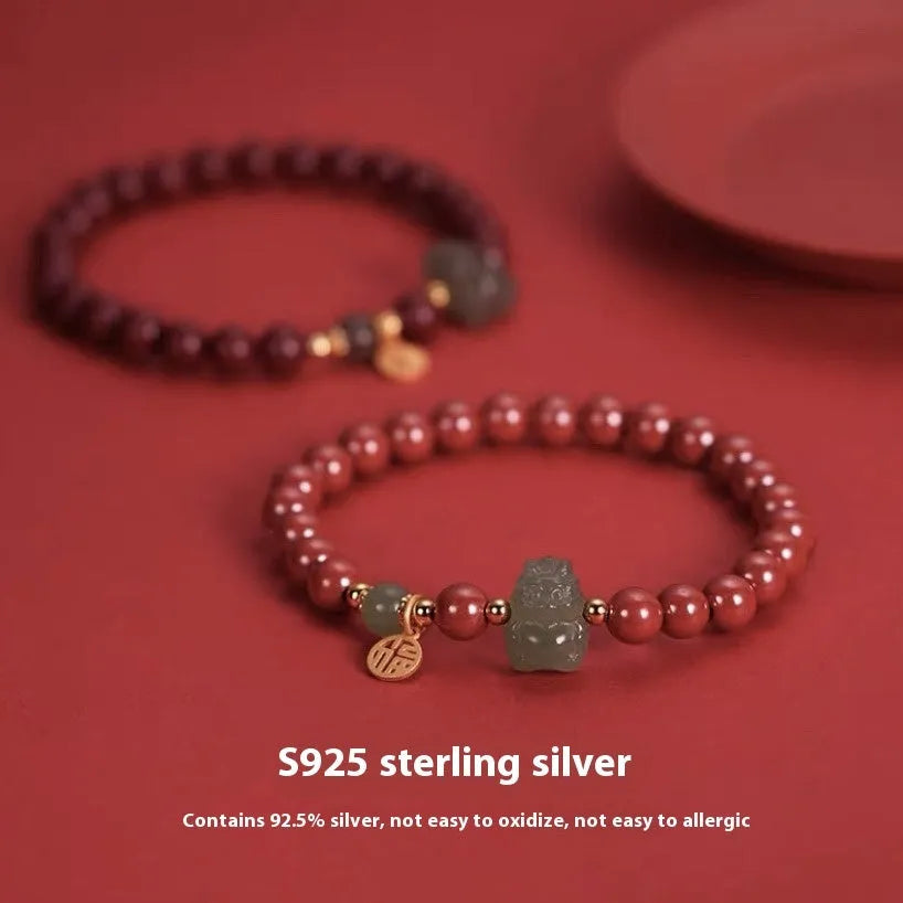Natural Hetian jade cinnabar bracelet with 8mm beads, Emperor Sandstone style, on display