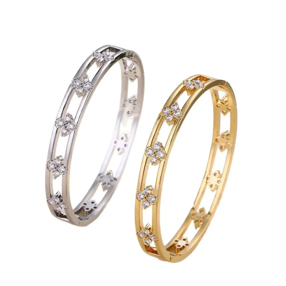 Gold and silver women's hollow bracelet with zircon inlay and a four-leaf clover design.