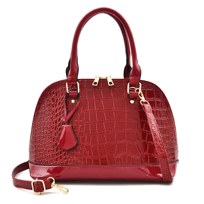 Large shiny black PU crossbody shoulder bag with shell suitcase shape on a white background.