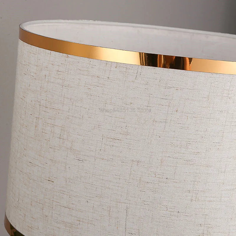 Simple bedroom table lamp with iron body and fabric shade in black finish on wooden desk