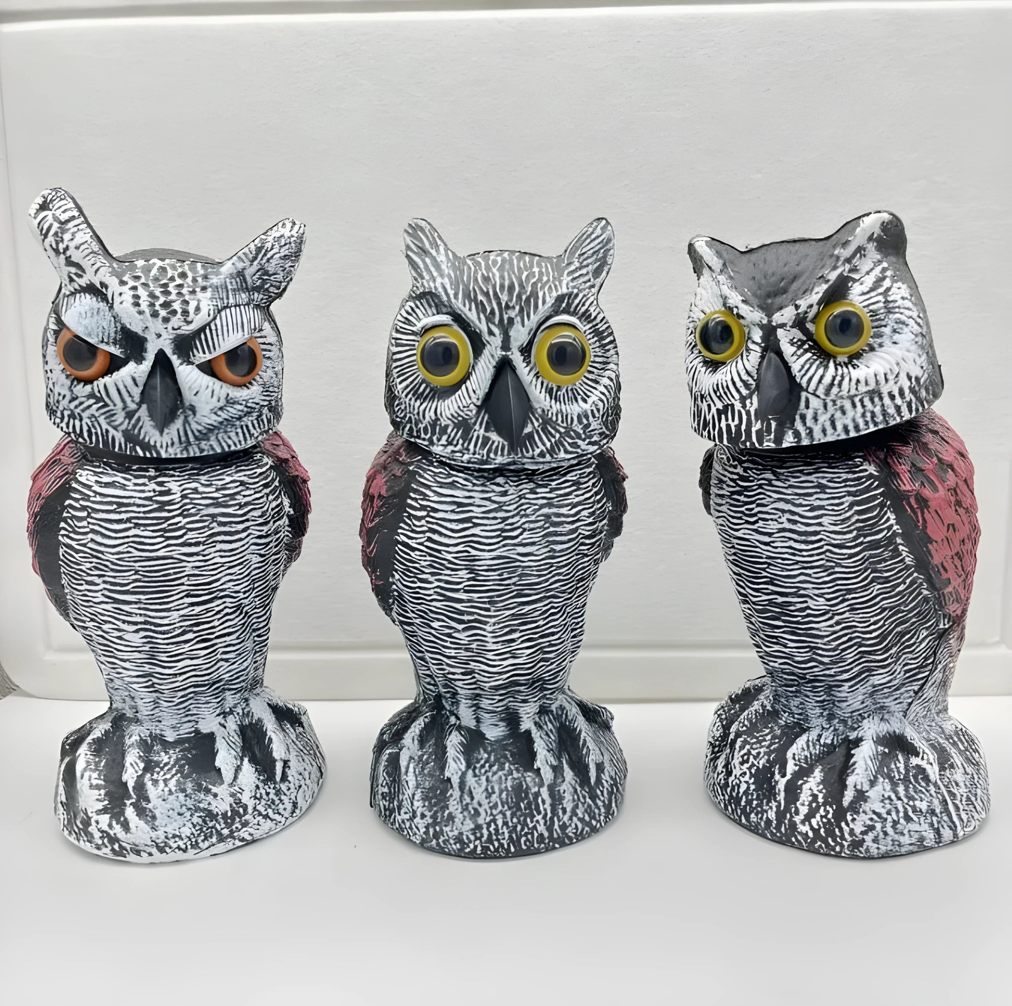 Artificial owl garden ornament with shaking head for bird deterrent on patio
