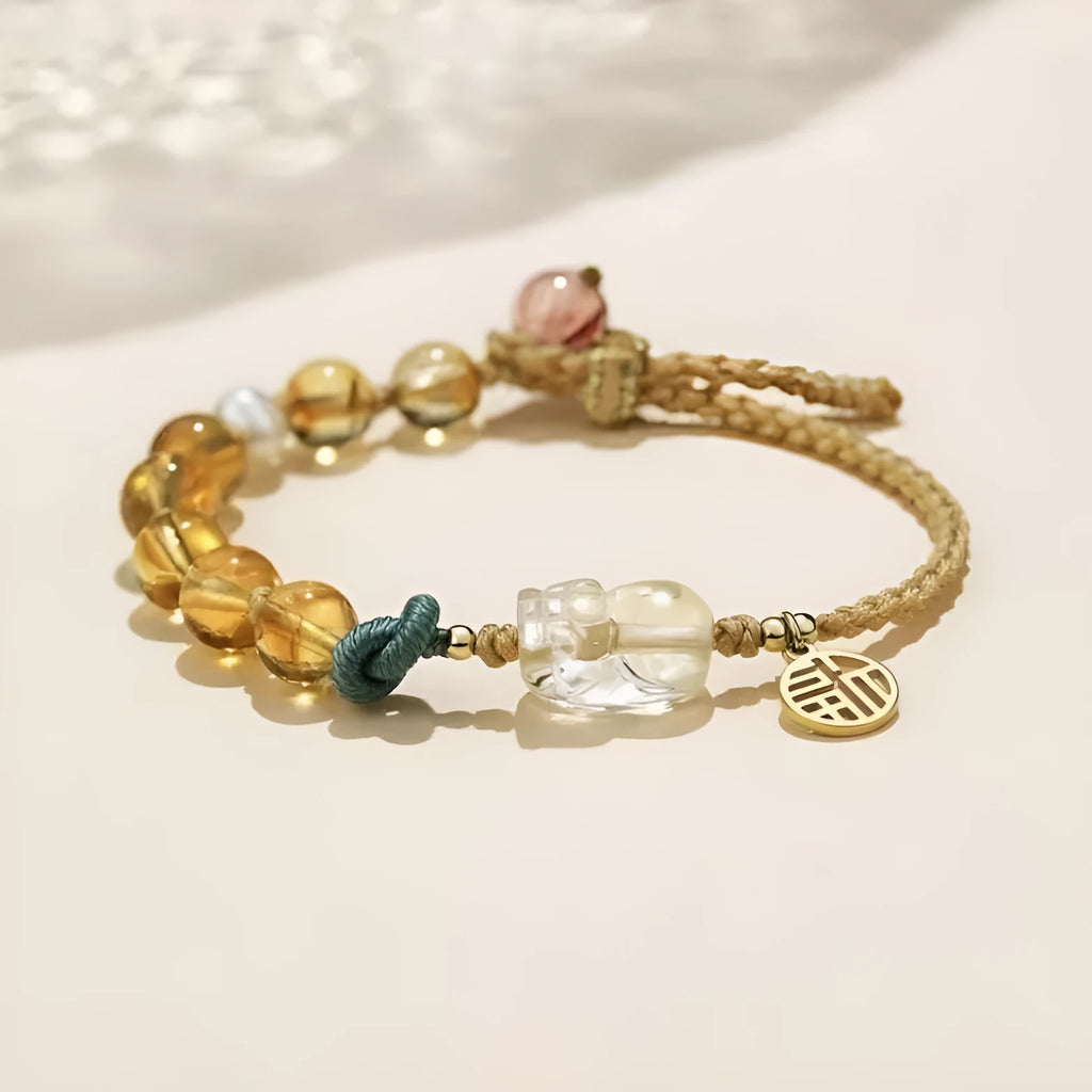 Hand-woven citrine crystal bracelet with zodiac design on neutral background