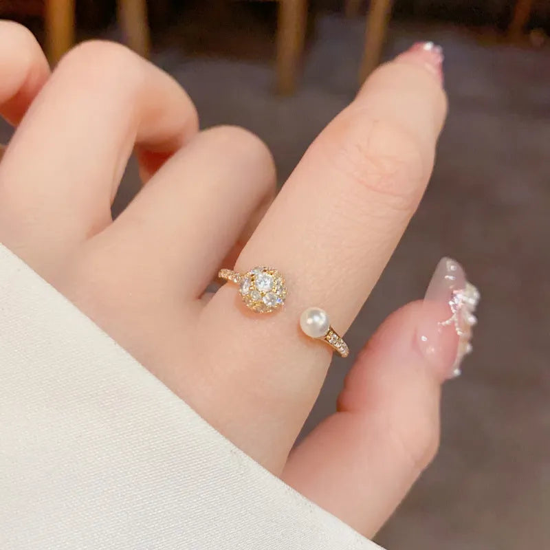 Women's open-end pearl ring with round zircon on geometric copper design in gold plating