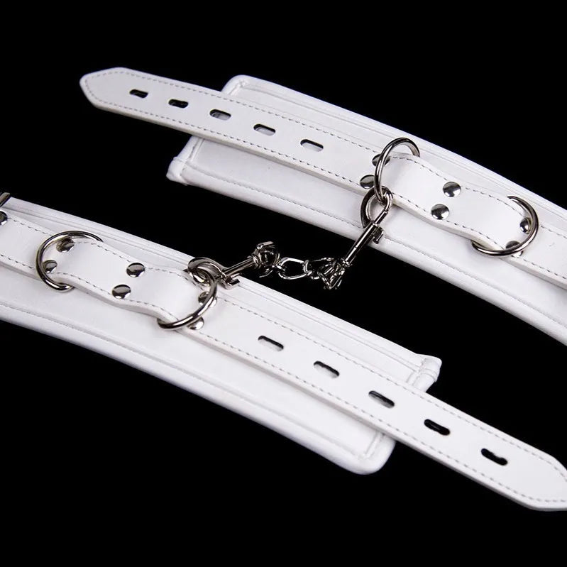 White PU sponge bondage ankle cuff and handcuff set with matching neck scarf on plain background