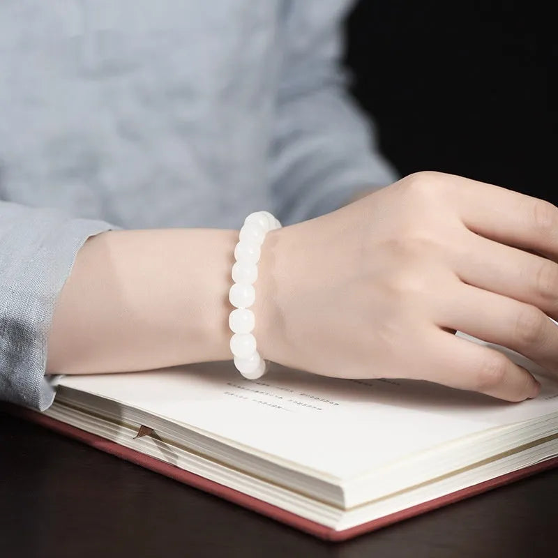 White Hetian jade barrel bead bracelet on a wrist, showing the unisex casual design.
