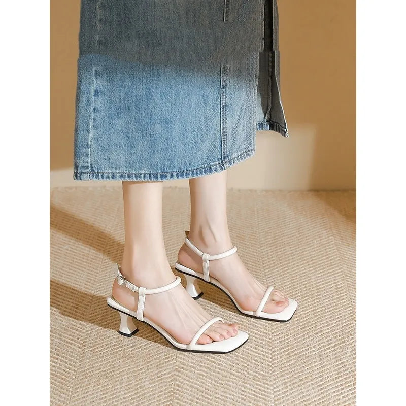 Black square toe high heel sandals with thick heel and one-line buckle strap on a white background