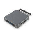 Square black Android TV set-top box with HDMI port and remote control on a wooden surface