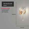 Modern gold swan-shaped wall lamp with acrylic shade mounted beside bed