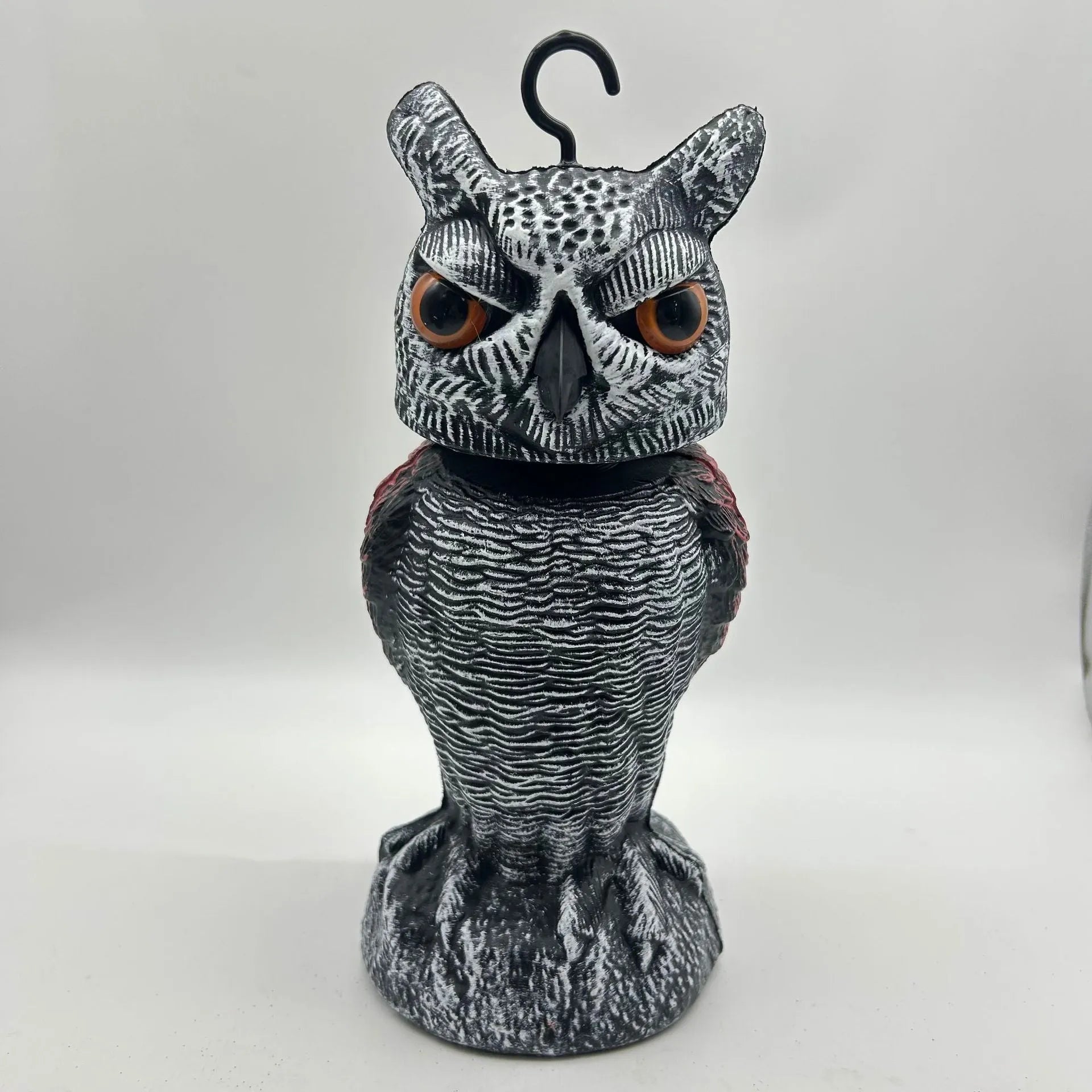 Artificial owl garden ornament with shaking head for bird deterrent on patio