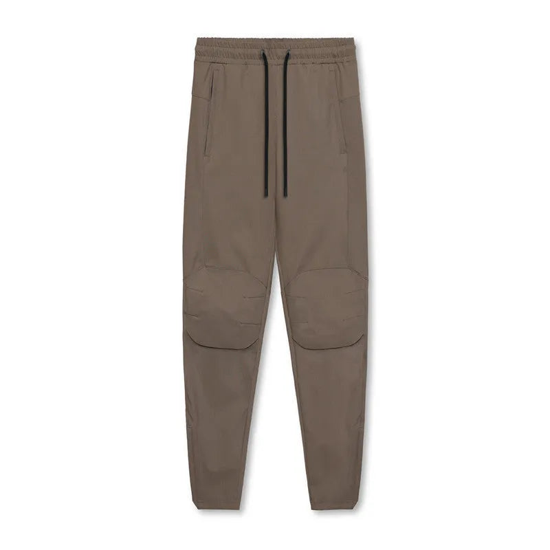 Men's grey quick-dry fitness trousers with ankle-tied design on exercise equipment