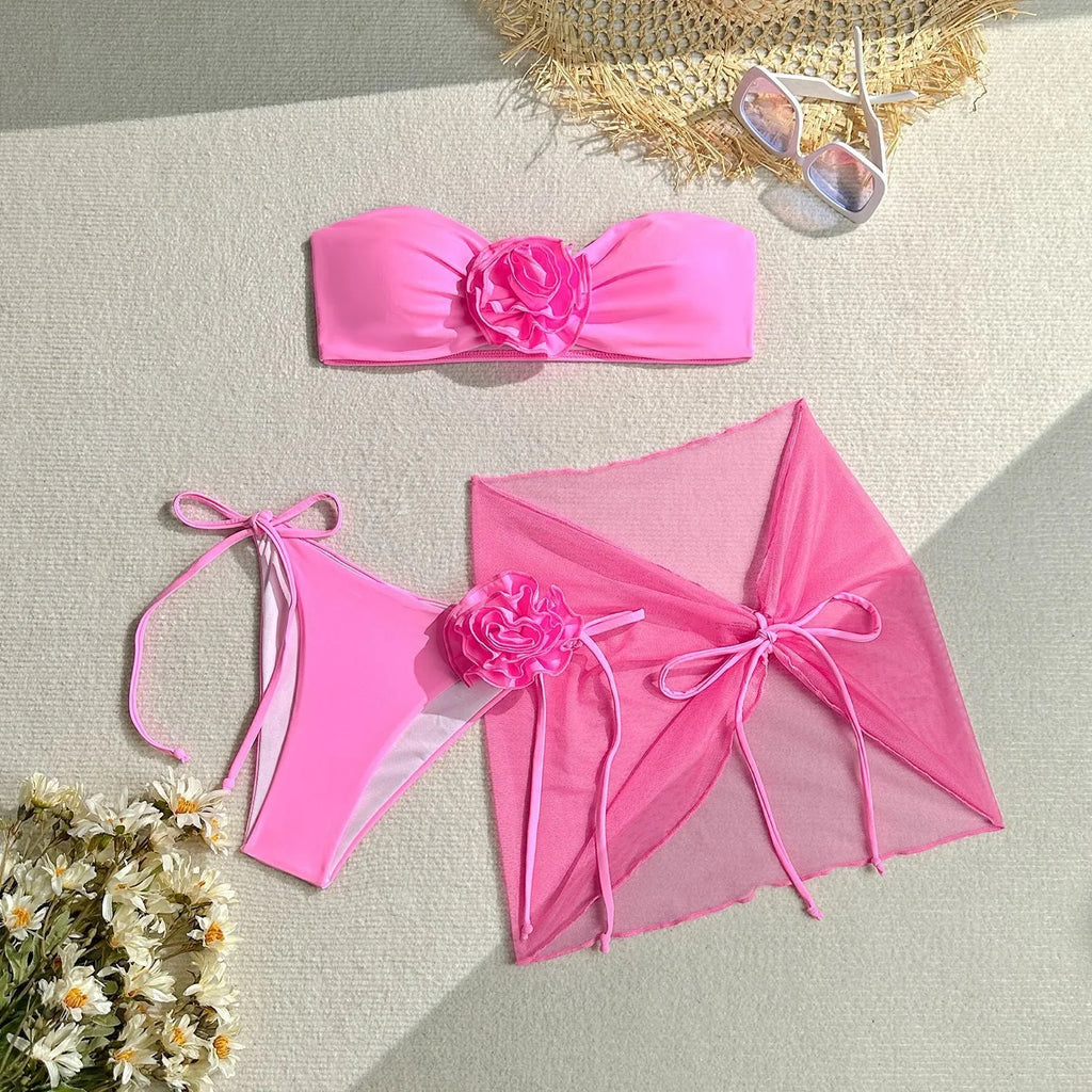 Women's pink tube top swimsuit with large 3D flower tie, matching skirt and bottom.