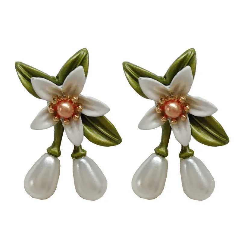 Silver colour needle camellia flower earrings showing stud and clip-on styles.