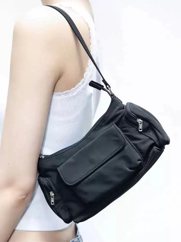Simple black lightweight women's PU shoulder bag with two front pockets and side line detail.