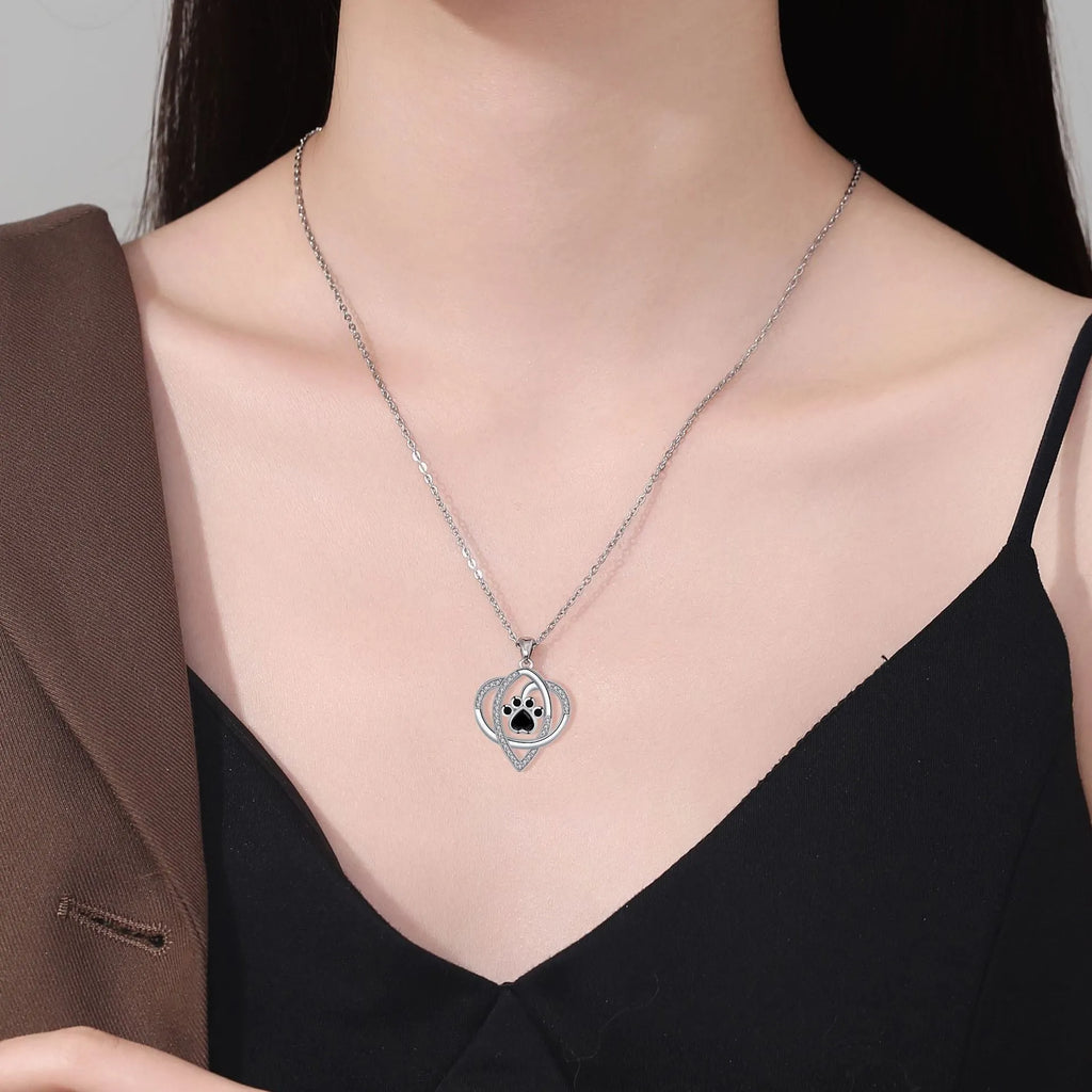 Close-up of electroplated copper paw print necklace pendant on adjustable cross chain