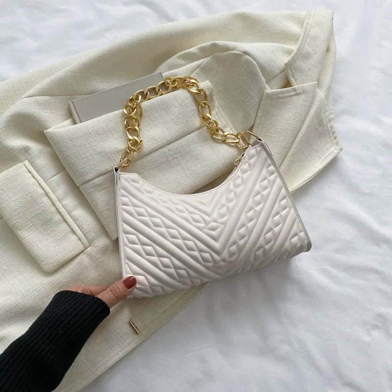 Black pleated chain baguette shoulder bag with adjustable strap and soft handle on white background