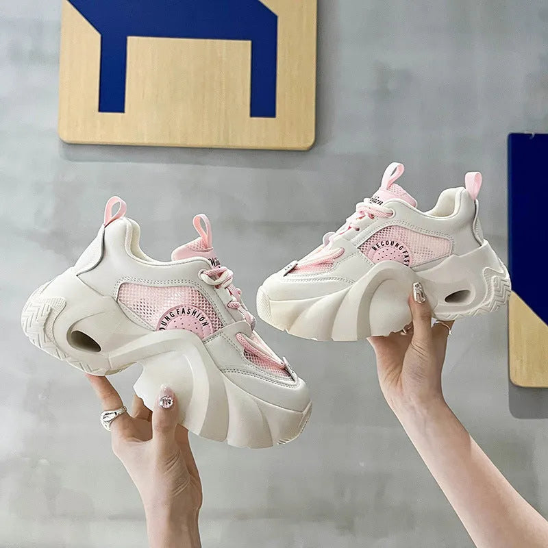 Women's pink sneakers with cross shoulder straps, thick platform sole, and breathable mesh lining.