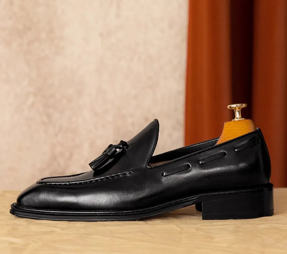 Men's black leather slip-on loafers with fringed detail and rubber sole