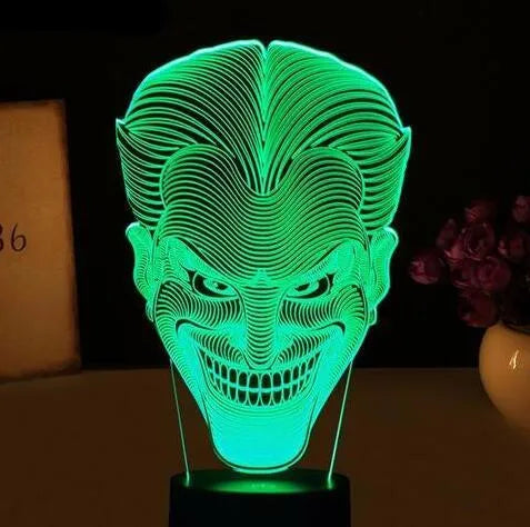 USB-powered 3D acrylic LED lamp showing colour gradient effect, with remote control and base on a desk.
