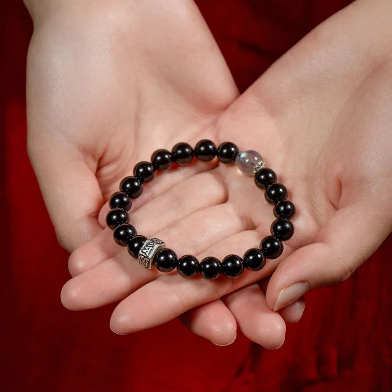 An ethnic-style women's bracelet made from 8mm obsidian beads with zodiac animal and Buddhist bodhisattva charms.