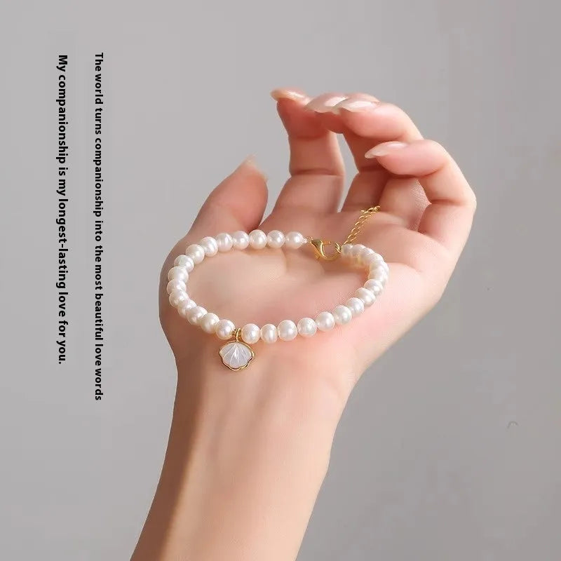 Women's freshwater pearl bracelet with fan-shaped design and alloy shell clasp, showing elastic string and extension chain options.