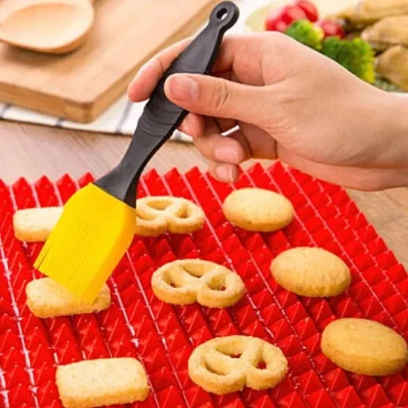 Red non-stick silicone pyramid cooking mat on a baking tray, showing grid pattern and 39.5 cm size